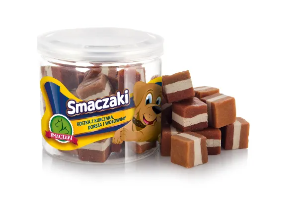 Przezroczysty słoik z żółtą etykietą marki stoi na białym tle, a obok niego leży kopczyk kostek o warstwach jasnych, rudobrązowych i ciemnych.