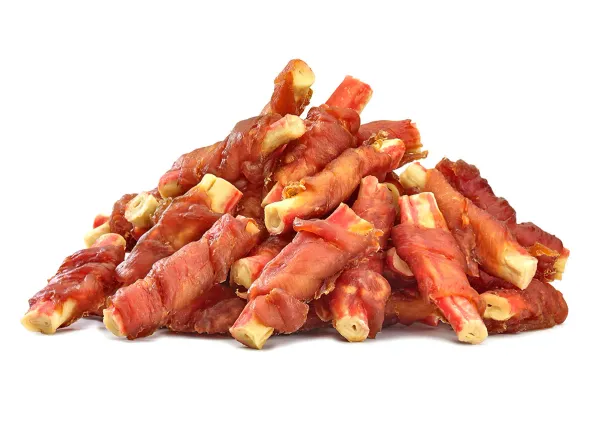 Jasne paluszki surimi owinięte paskami czerwonego mięsa kurczaka tworzą kopczyk.