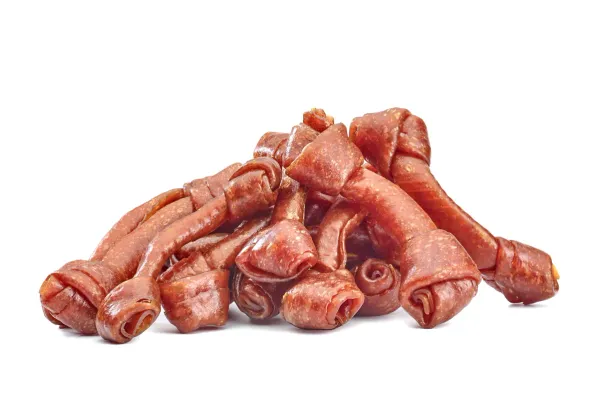 Skręcone rolki z mięsa kaczki o różowej barwie leżą luzem obok siebie.